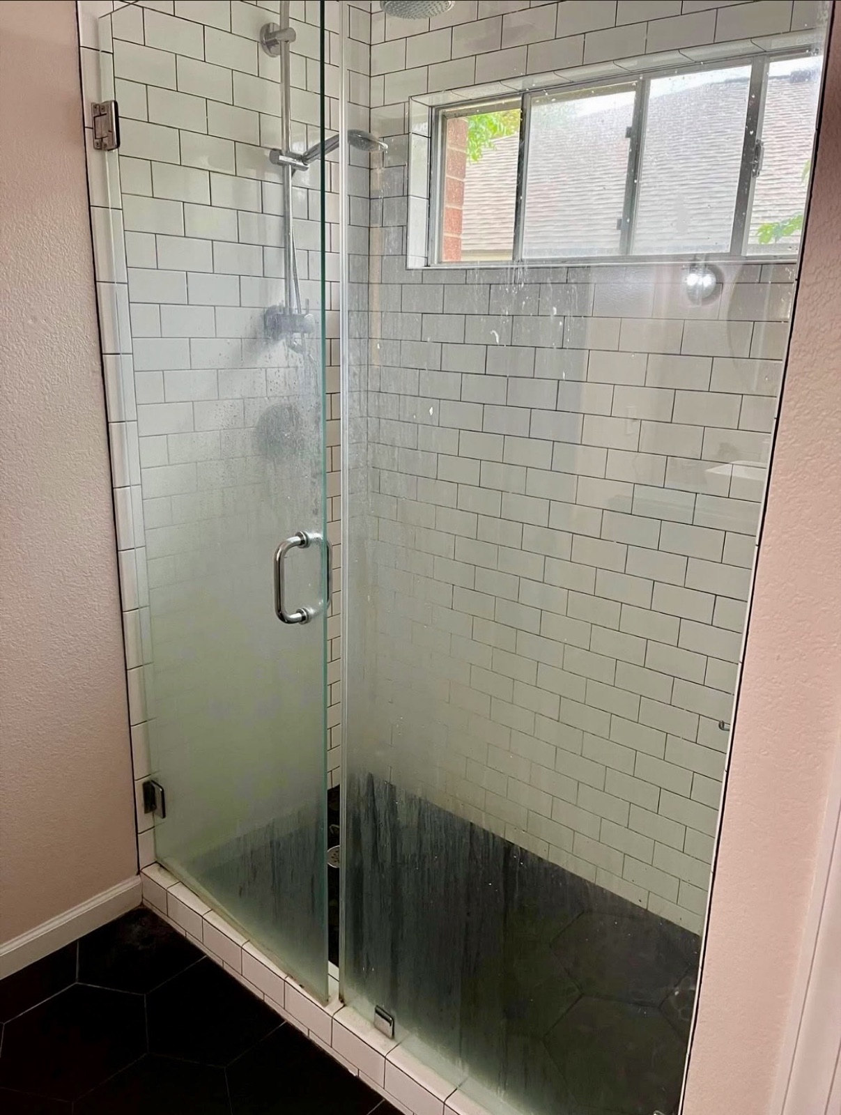 Shower glass with soap-scum buildup before deep cleaning